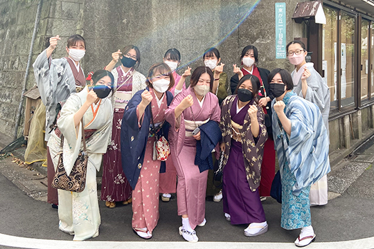 茶道教室の前で集合写真を撮る織田着物専門学校の着物科の学生たち