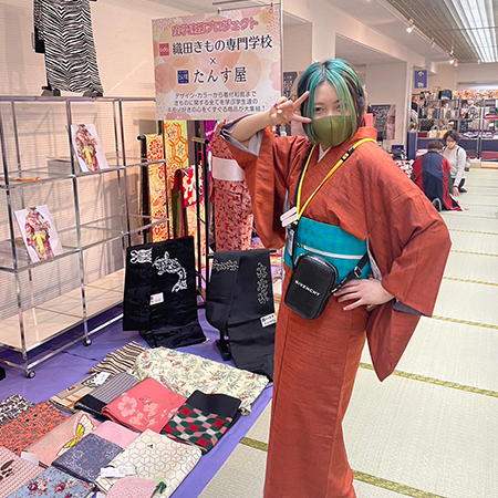 名古屋帯の販売ブースに立つ織田着物専門学校の着物科の学生