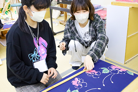 織田着物専門学校着物専攻科学生から裁断の説明を受ける着物科学生