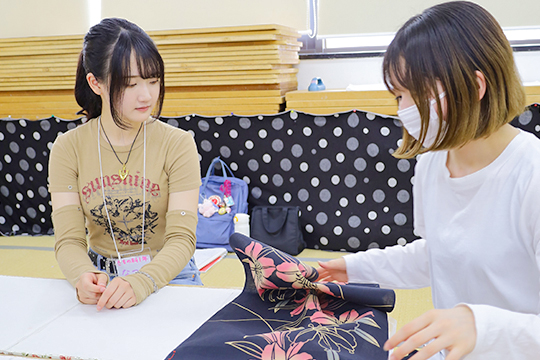 着物科学生の裁断を補助する織田着物専門学校着物専攻科の学生