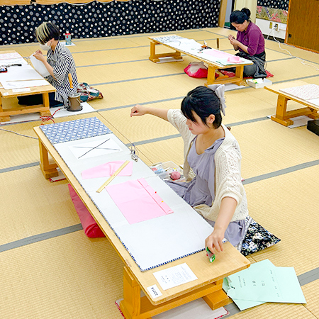 和裁検定の実技試験で部分縫いを行う織田着物専門学校着物専攻科の学生たち
