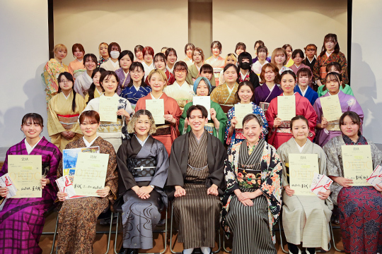 着物コンテストの審査員と賞状を受け取る織田着物専門学校着物科学生たち