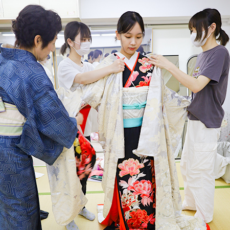 講師から花嫁衣装の着付け指導を受ける織田着物専門学校着物研究科学生
