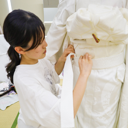 白無垢の腰ひもを絞める織田着物専門学校着物研究科学生