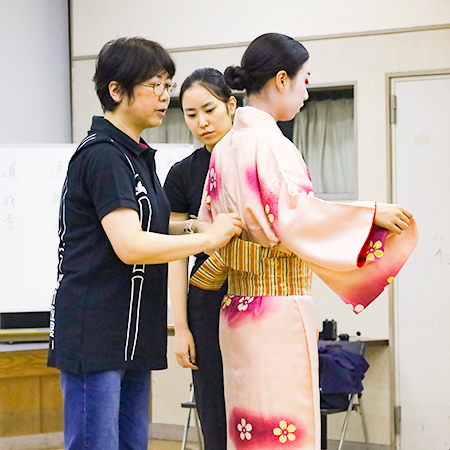 着付けを行う松竹衣裳株式会社の着付け師と織田着物専門学校着物科学生