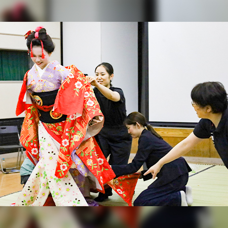 舞台衣装の着付け実演にて引き抜きを行う織田着物専門学校着物科学生